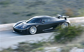 Black Koenigsegg supercar in speed