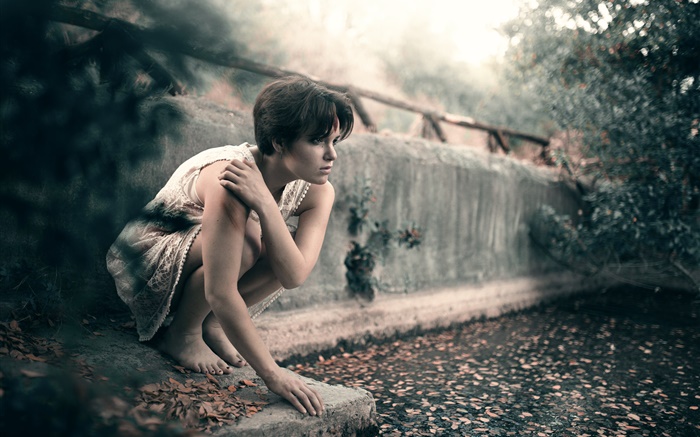 Short hair girl, sits, leaves, blur background Wallpapers Pictures Photos Images